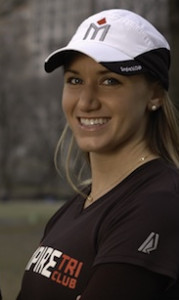 Smiling woman wearing sports cap outdoors.