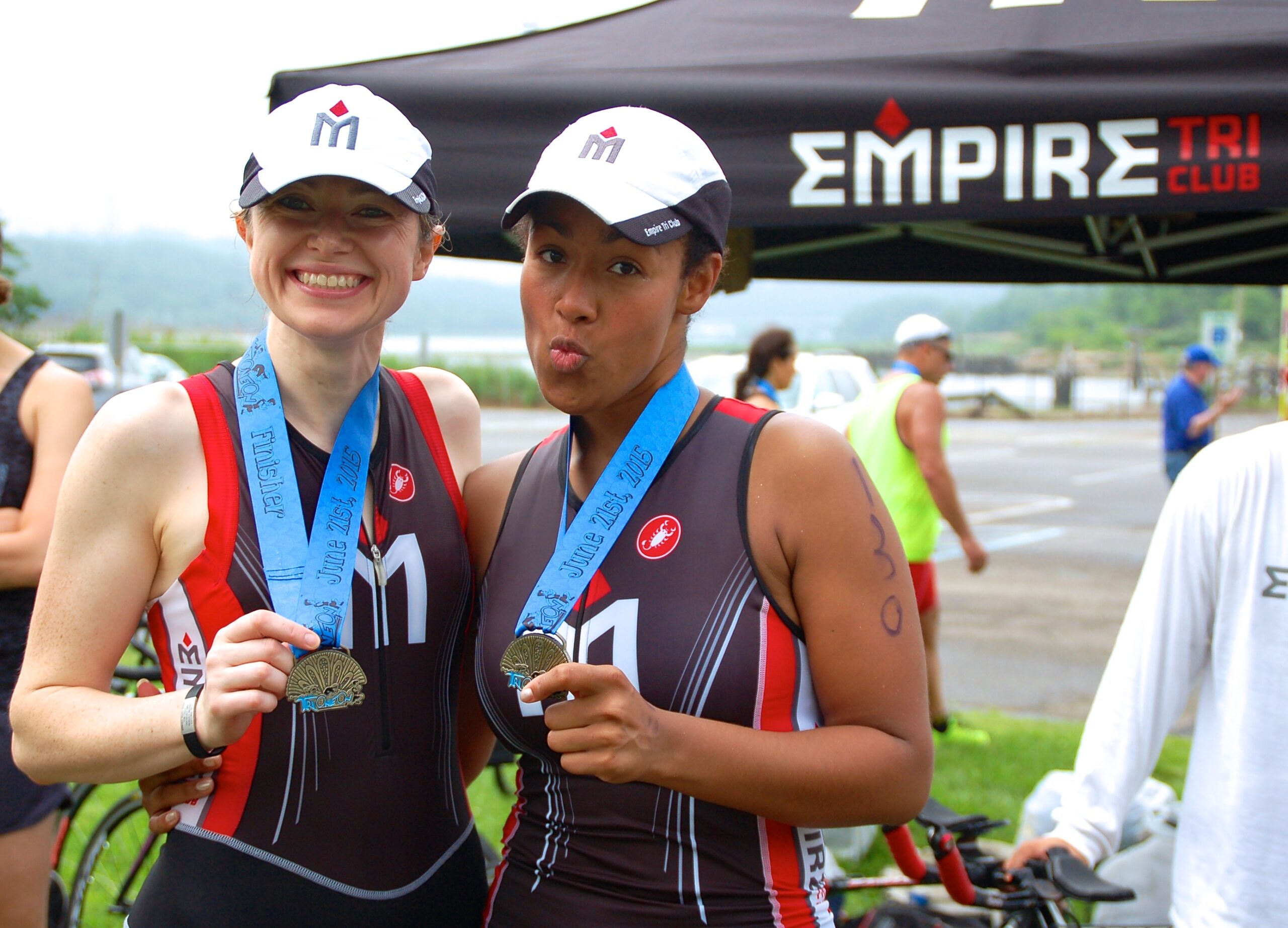 Two women standing next to each other holding medals.