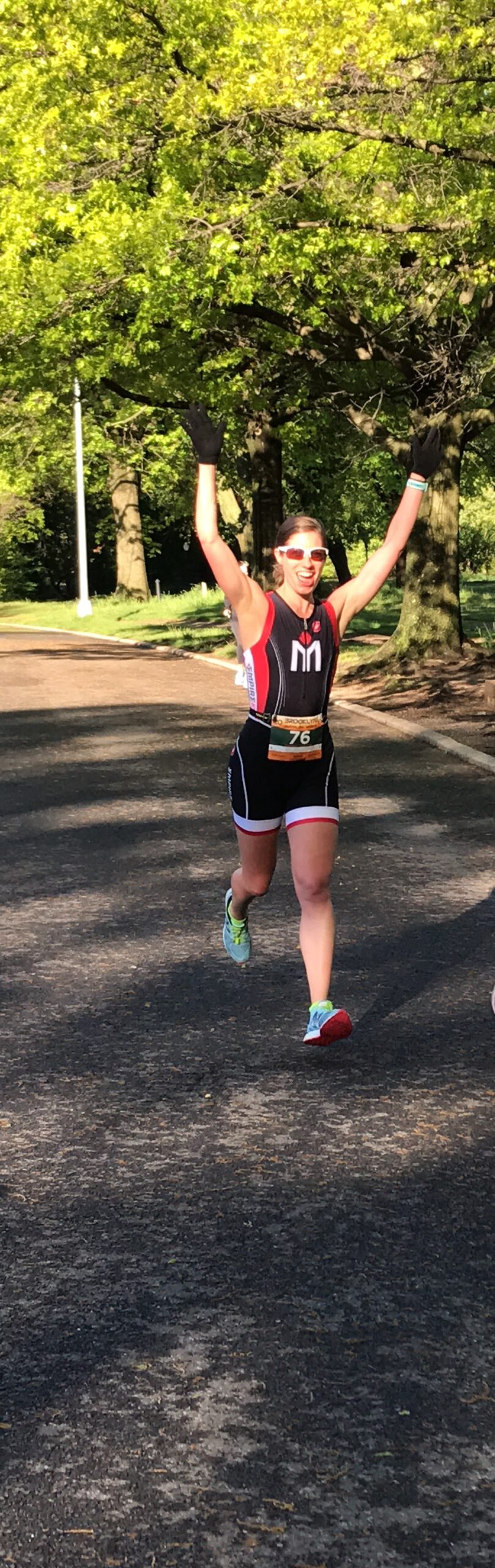 A woman running in the street with her arms raised.
