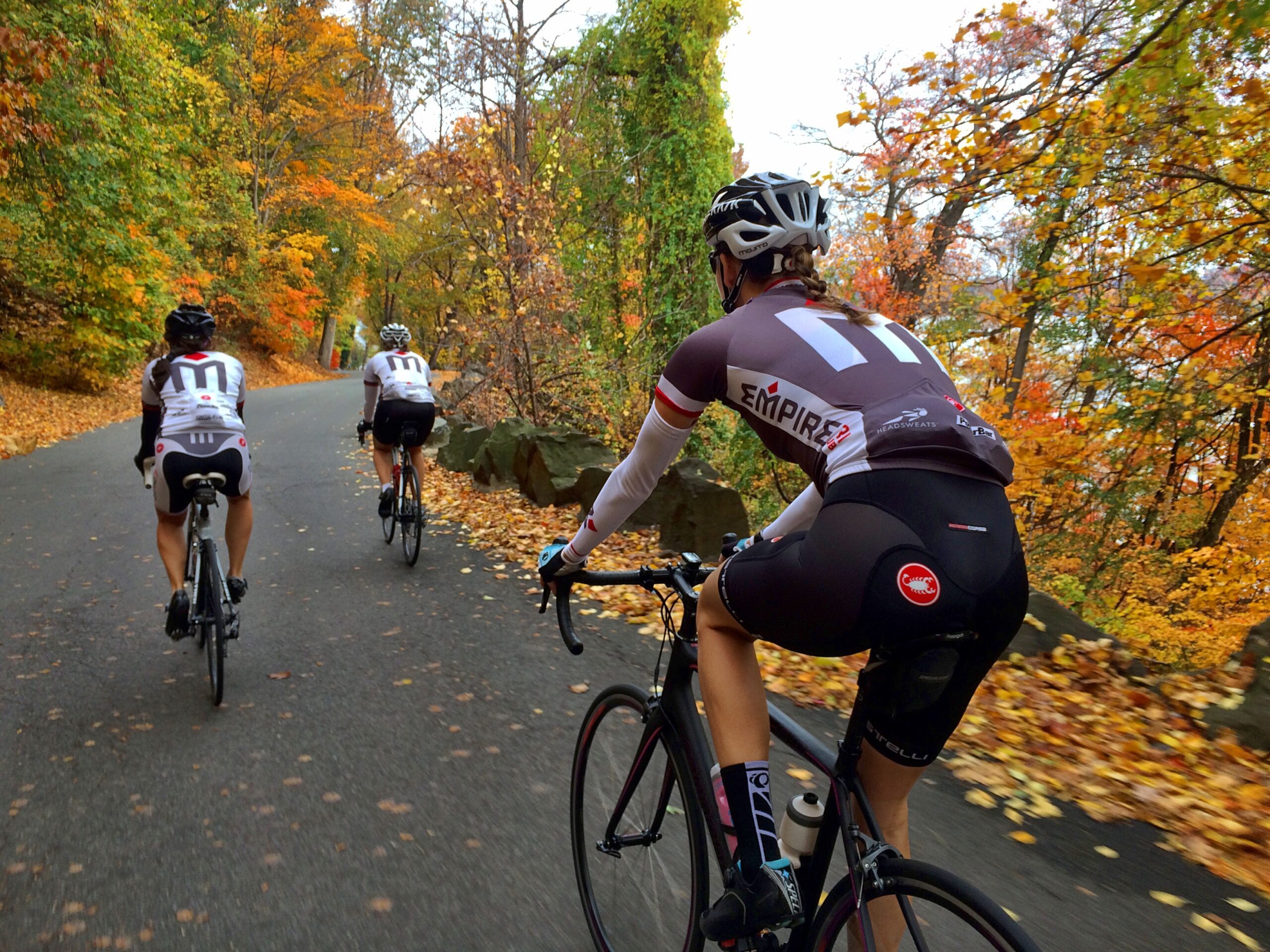 A group of people riding bikes down the road.