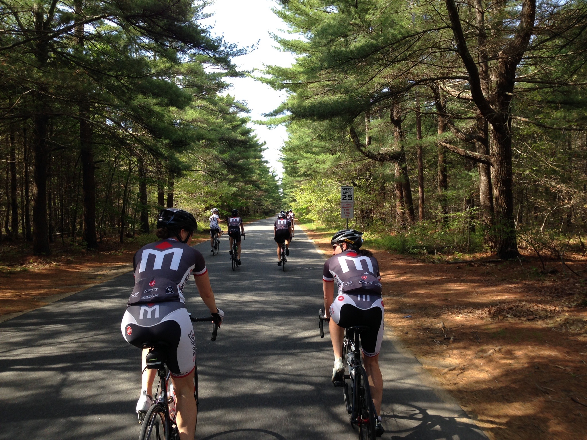 A group of people riding bikes down the road.